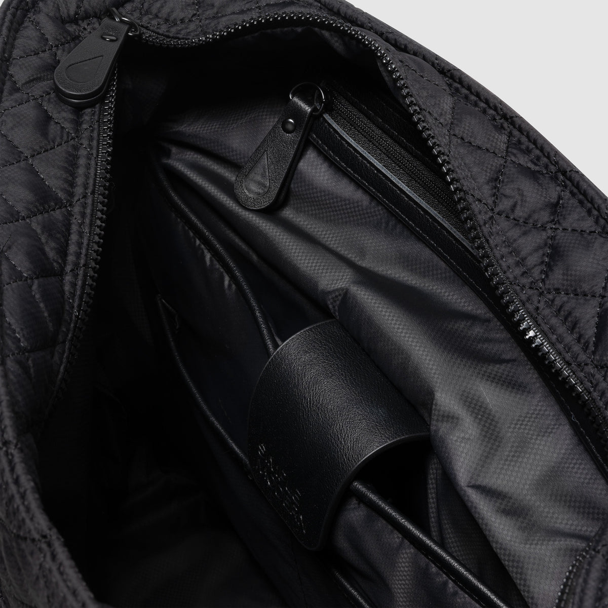 Black and charcoal gray messenger bag interior showing black fabric lining with subtle shadows and light gradations creating depth